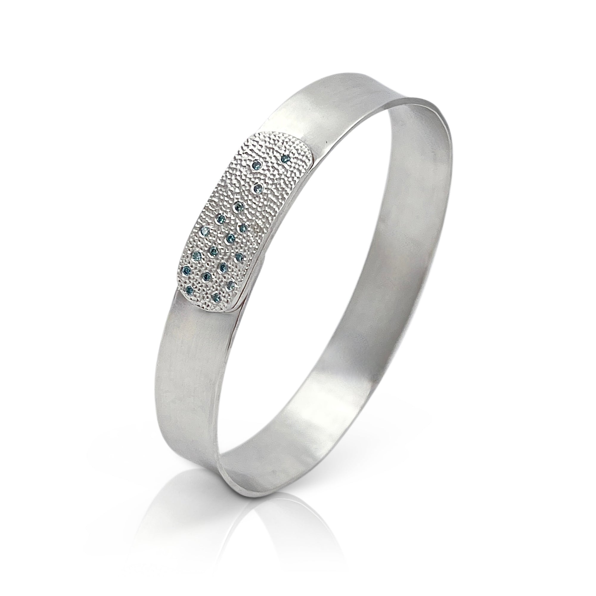 Narrow forged cuff in sterling silver (white) with top closure and blue diamonds