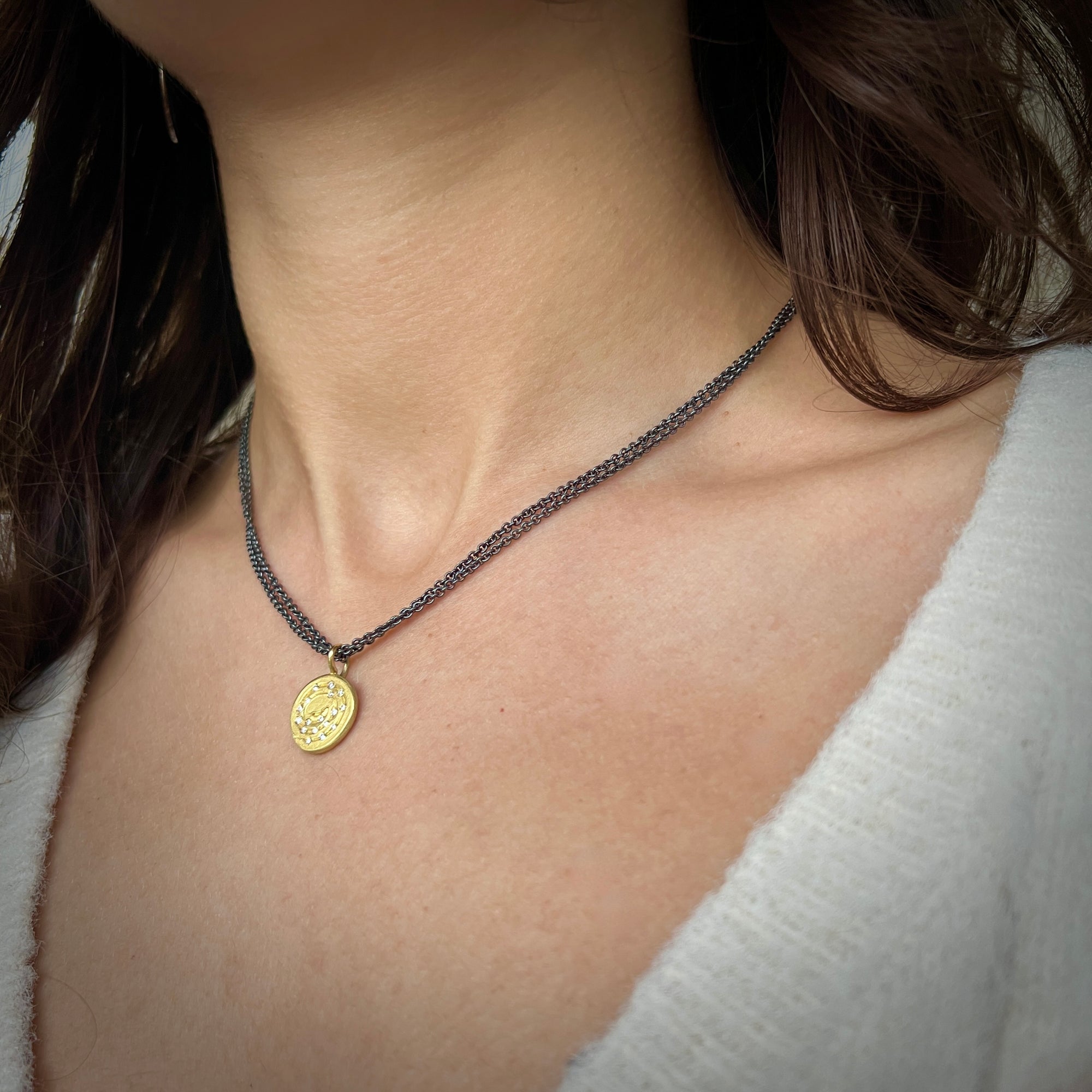 Spiral, coin-like pendant in 18K yellow gold with 17 diamonds double oxidized sterling silver chain made by Ayesha Mayadas