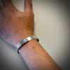 Men’s rugged sterling silver cuff with top latching mechanism made by Ayesha Mayadas shown on a model