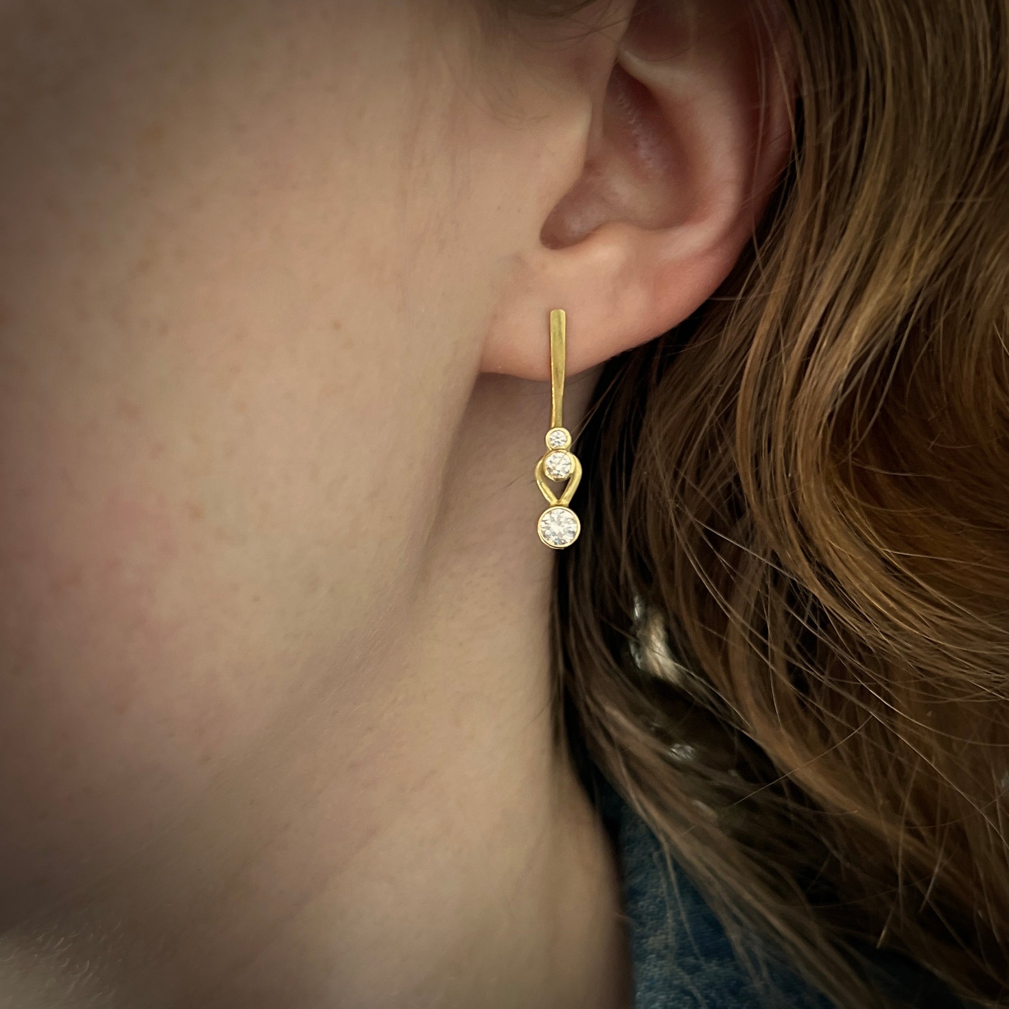 Earrings in 18K gold with stacked diamond drops with natural and lab grown diamonds shown on model made by Ayesha Mayadas