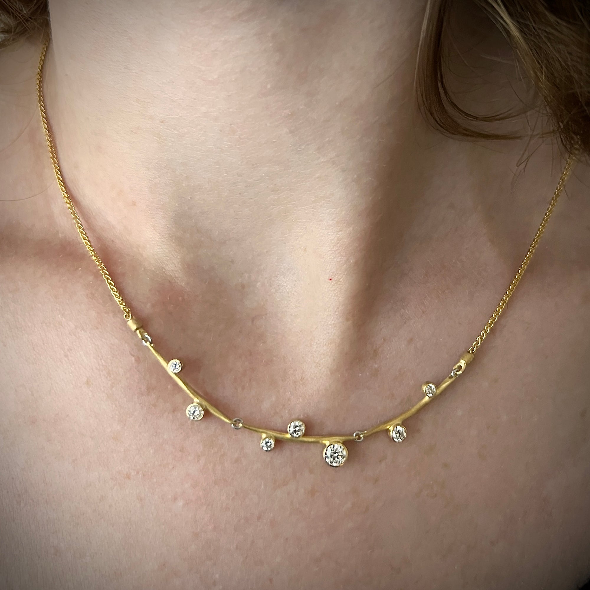 Three forged links with a stepped placing of diamonds form a flexible in-line pendant in 18KY gold made by Ayesha Mayadas