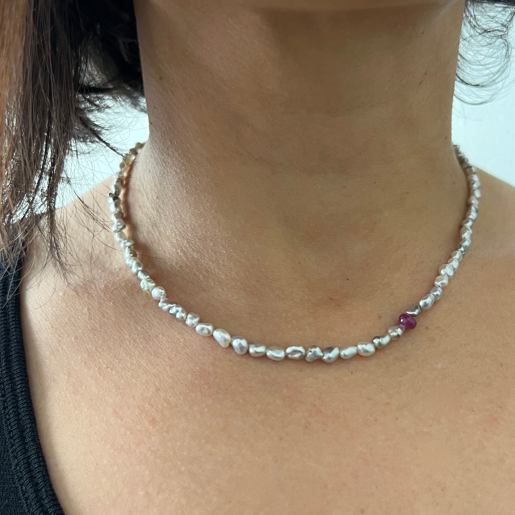 Tiny Tahitian pearl strand with a single ruby bead and platinum clasp