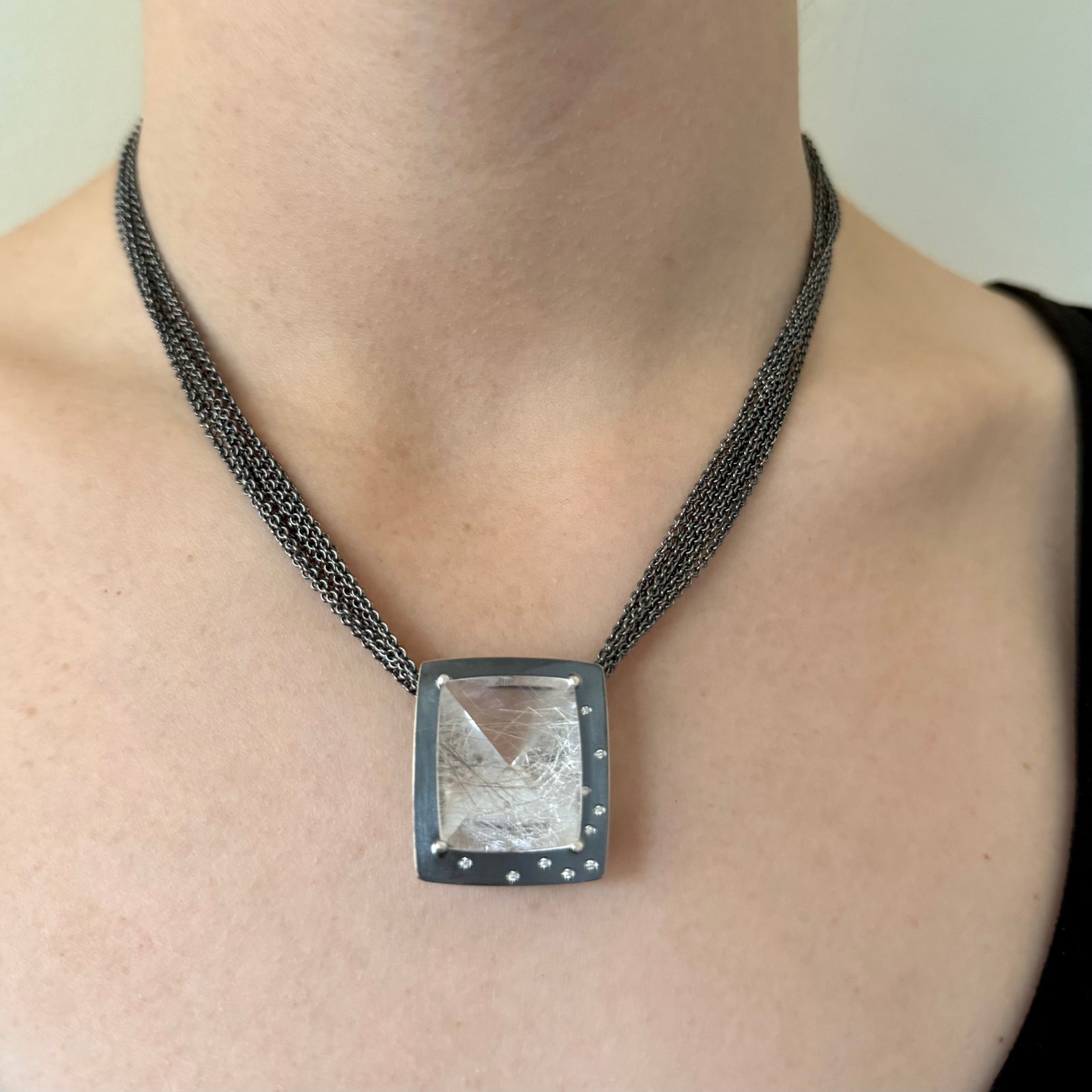 A fine, lens cut, rutilated quartz necklace with diamonds on multi sterling chain