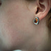 Geometric Sterling Silver earrings with 18kt gold rivets and oval Spessarsite garnet shown on model by Ayesha Mayadas