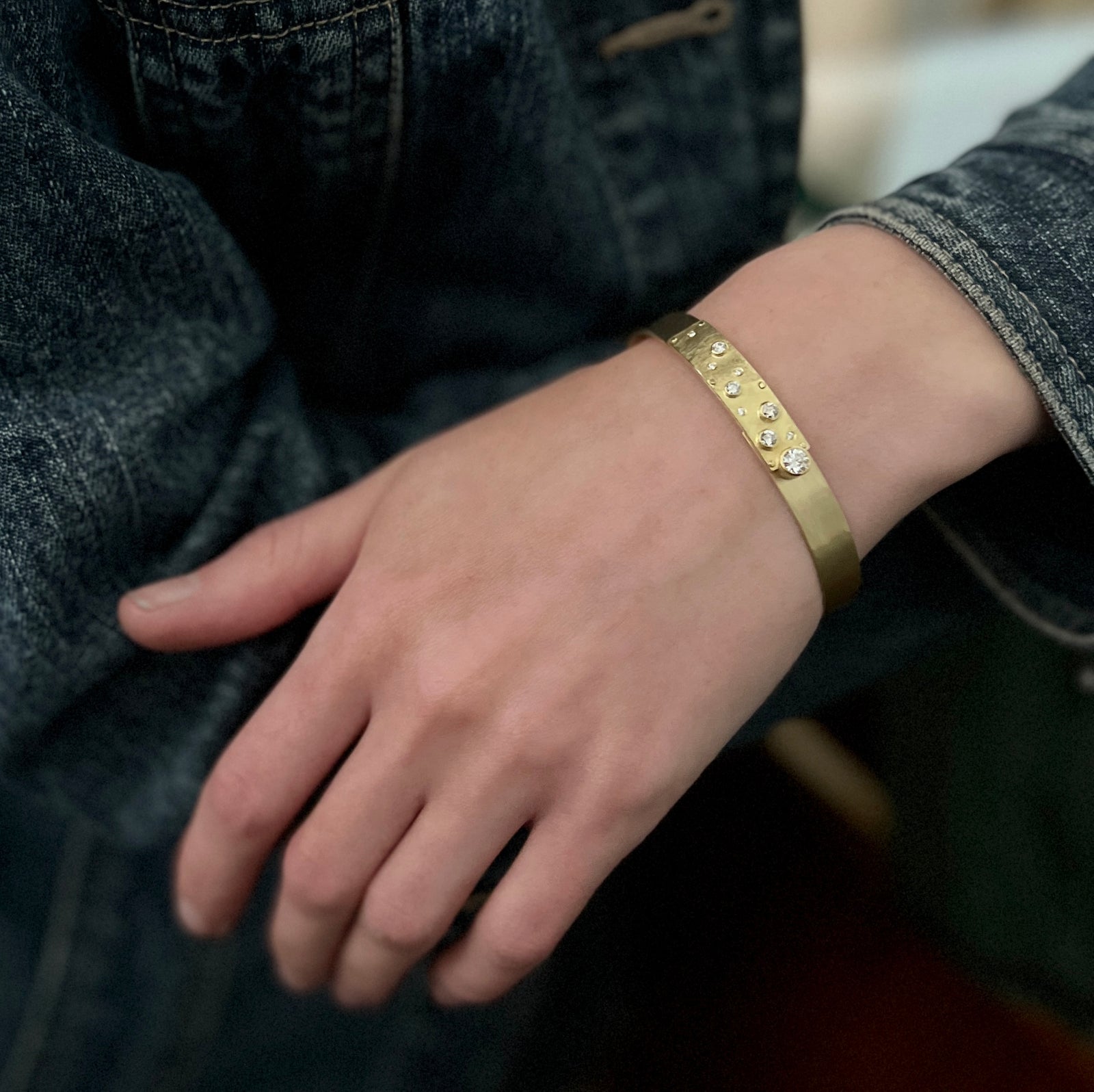 A very stackable narrow cuff that has been forged and designed to close at the top just under the textured and diamond tab. Made by Ayesha Mayadas