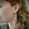Persian turquoise stud earrings with 18K gold setting and post shown on model made by Ayesha Mayadas