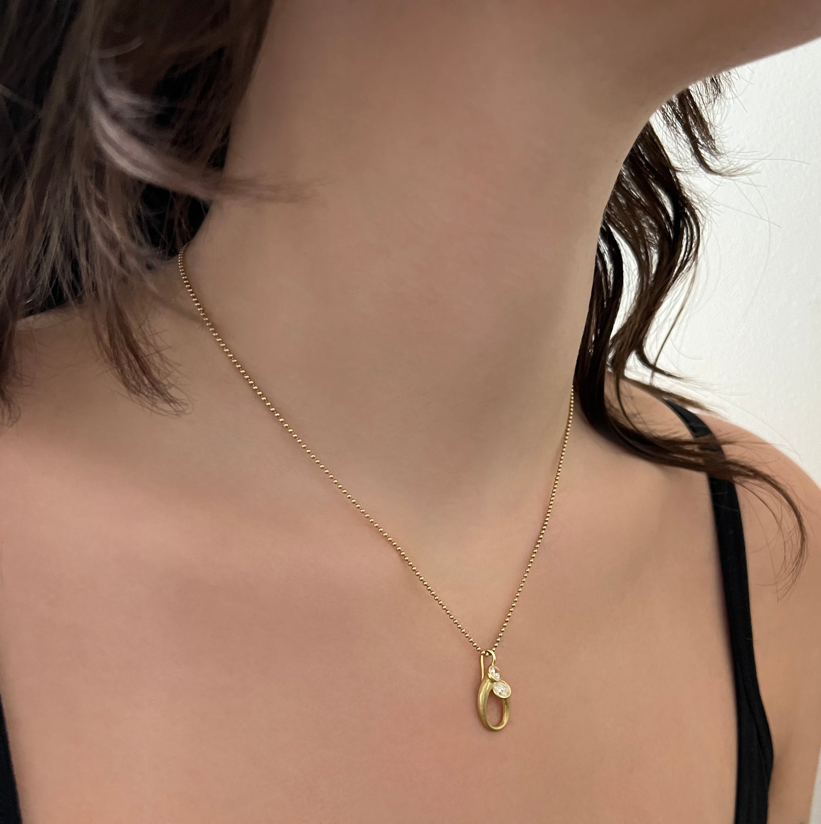 18Kt and oval diamond pendant in an embrace motif or mother and child motif.  Made by Ayesha Mayadas