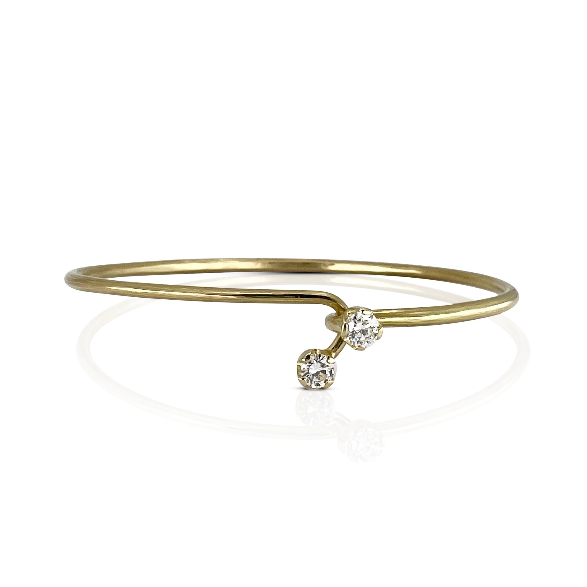 18K yellow gold cuff with two natural diamonds on a white background