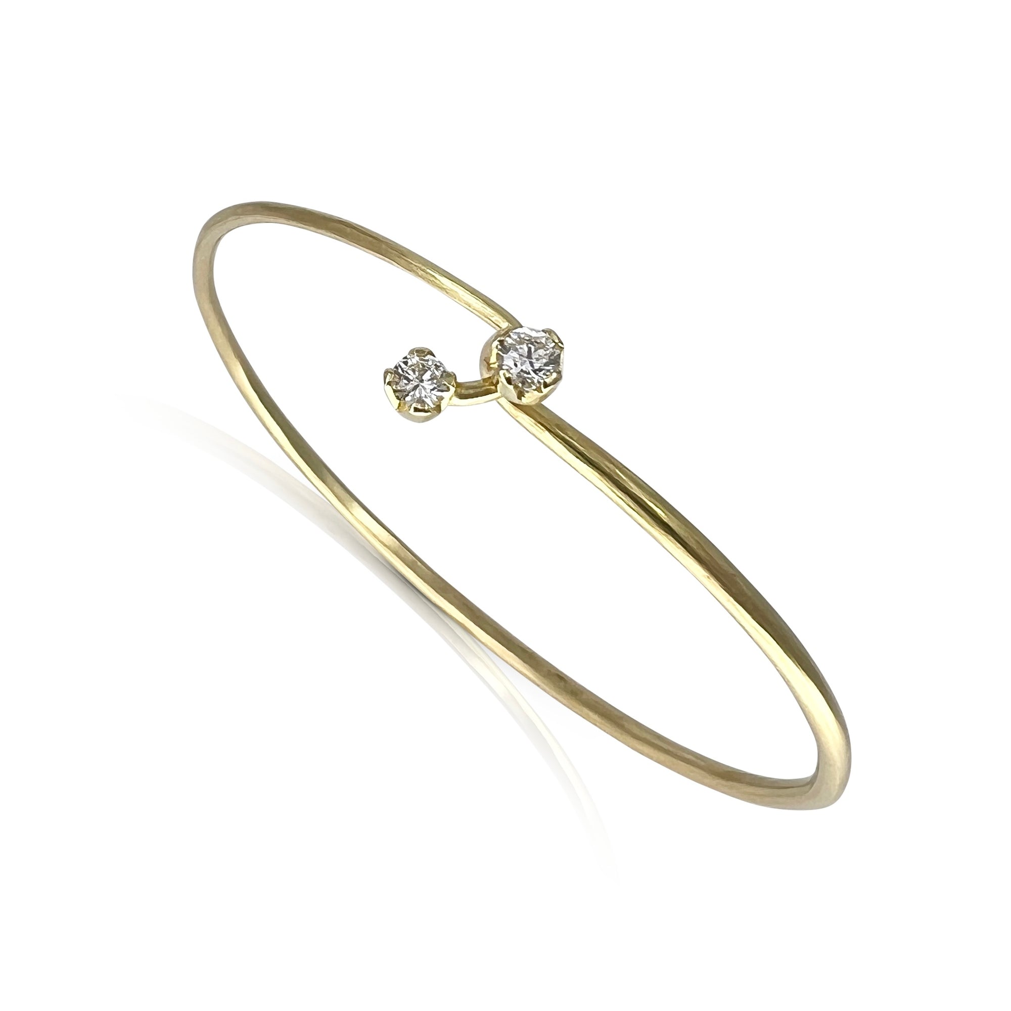 18K yellow gold cuff with two natural diamonds on a white background