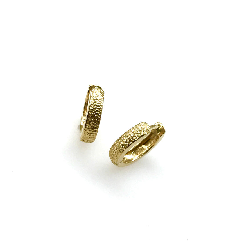 Huggie style hoop earrings in 14K gold with dappled texture by Ayesha Mayadas
