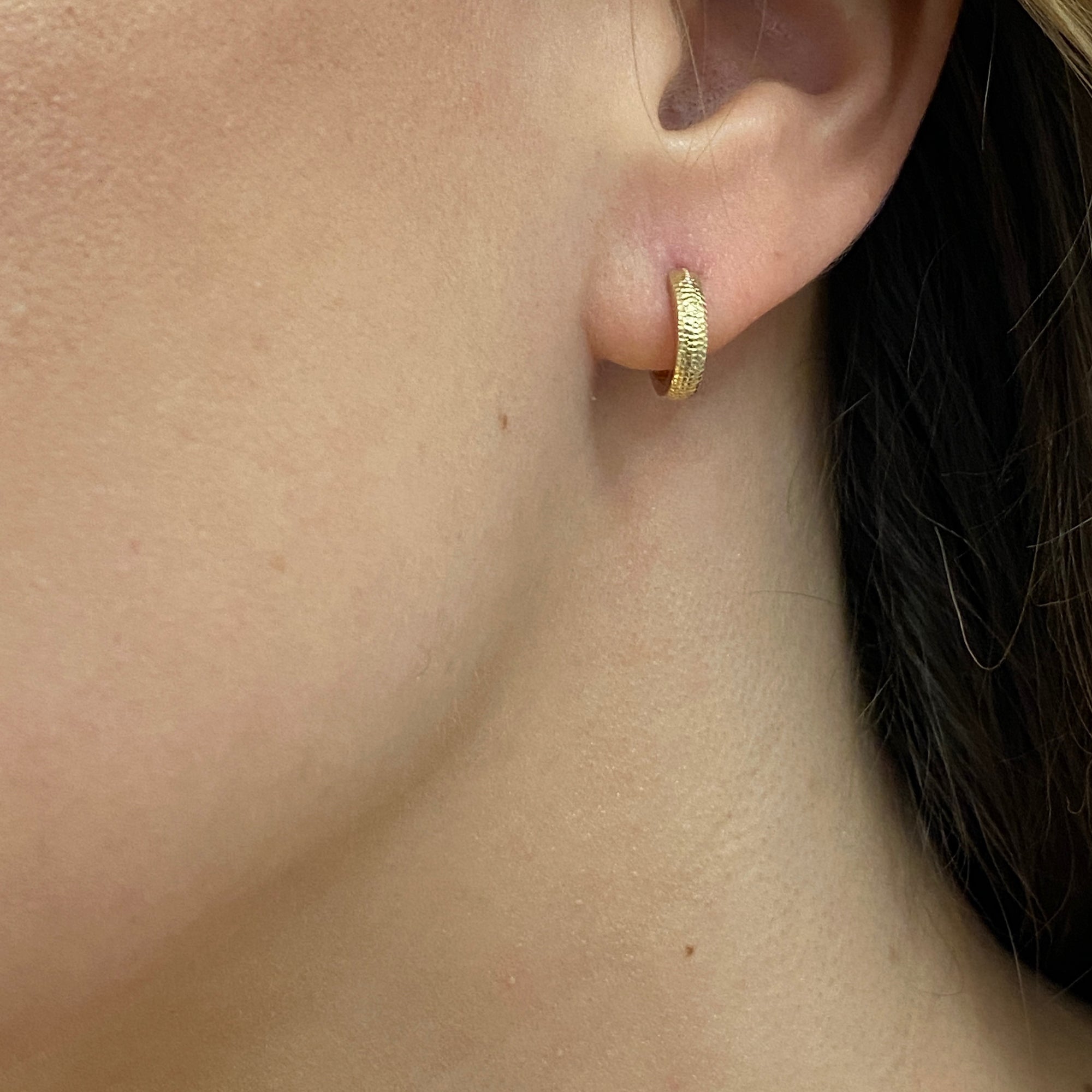 Huggie style hoop earrings in 14K gold with dappled texture by Ayesha Mayadas