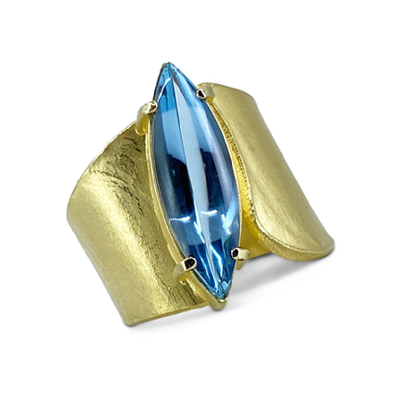 Wide Wafer texture ring in 18K yellow gold with marquis shaped cabochon aquamarine shown on model by Ayesha Mayadas