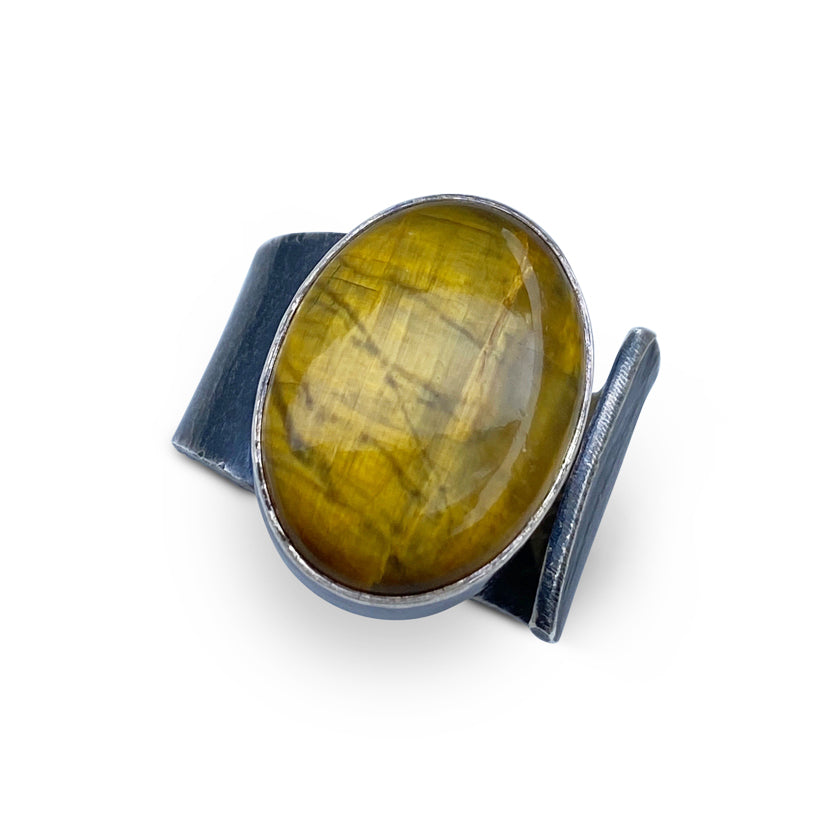 Wide oval shaped Nellite ring with a tiger's eye appearance in wafer textured sterling silver by Ayesha Mayadas
