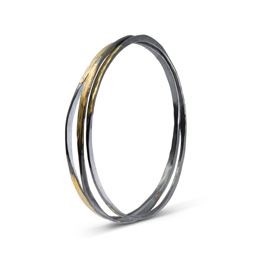 Oxidized sterling silver off-round bangle bracelet with 14K yellow gold overlay by Ayesha Mayadas