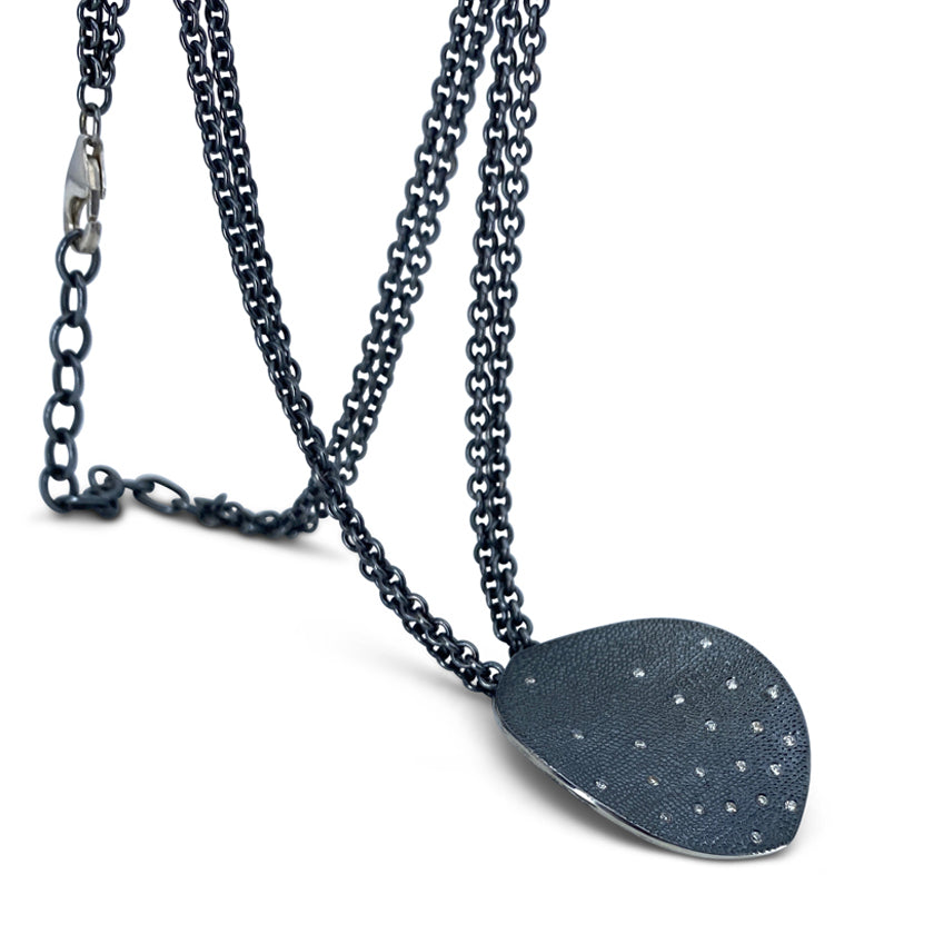 Leaf pendant in oxidized sterling with diamonds on double chain shown on model made by Ayesha Mayadas