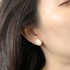 Asymetric 18K yellow gold, pearl and diamond earrings shown on a model.  Earrings made by Ayesha Mayadas