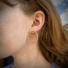 Simple spiral earrings in forged sterling silver with gold Vermeil finish shown on model made by Ayesha Mayadas