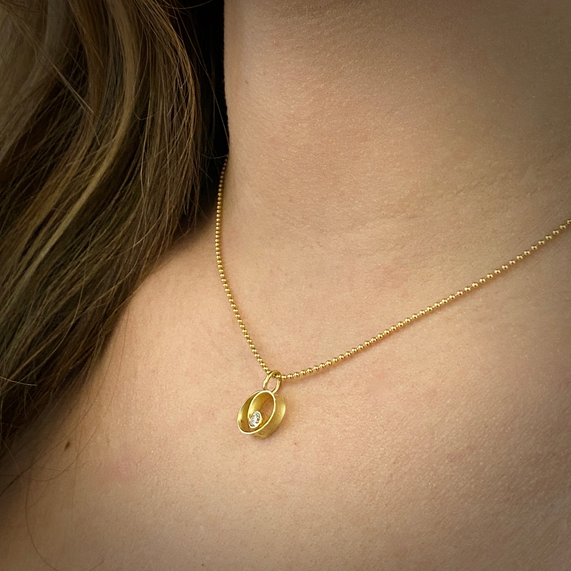 Coil style pendant in 18K yellow gold with diamond by Ayesha Mayadas