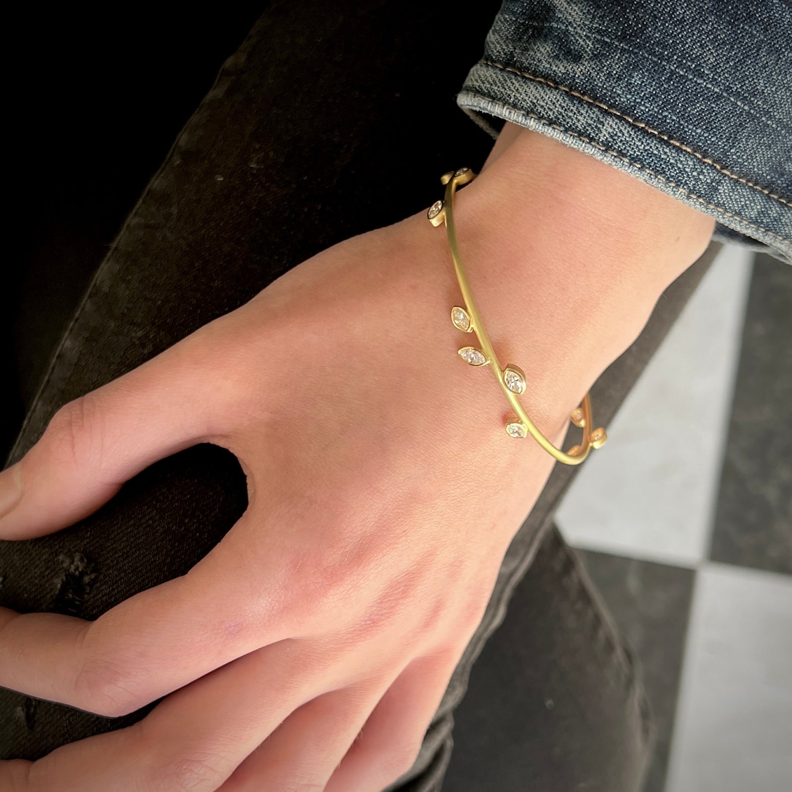 bangle bracelet in 18K Gold with 14 leaf shaped marquis diamonds shown on model made by Ayesha Mayadas