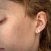 Shell-like creamy pearl studs in 18K yellow gold