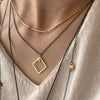 A collection of layered necklaces in 18KY gold and sterling silver by Ayesha Mayadas