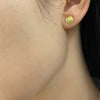Petite concave 18K yellow gold brush finish earrings with 0.30 ct tw diamonds shown on model by Ayesha Mayadas