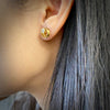 Model wearing an 18K yellow gold stud style coil earring with diamonds by Ayesha Mayadas 